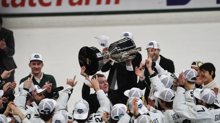 Michigan State hockey coach Adam Nightingale hoists the Big Ten tournament championship trophy after the Spartans beat Michigan 5-4 in overtime in Saturday night's title game at Munn Ice Arena in East Lansing.