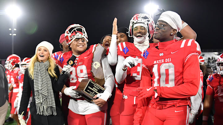 Mater Dei football players are all smiles with the 2024 CIF State Open Division trophy after beating De La Salle 37-15 at Saddleback College. Recently, the school signed a 10-year media rights deal with Playfly Sports with an estimated annual value of $1 million. This package is to help student athletes navigate the NIL landscape and to enhance the already prestigious private high school. Mater Dei football players are all smiles with the 2024 CIF State Open Division trophy after beating De La Salle 37-15 at Saddleback College. Recently, the school signed a 10-year media rights deal with Playfly Sports with an estimated annual value of $1 million. This package is to help student athletes navigate the NIL landscape and to enhance the already prestigious private high school.