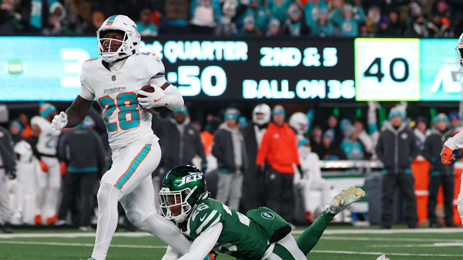Miami Dolphins running back De'Von Achane (28) runs with the ball while avoiding a tackle attempt by New York Jets cornerback Brandin Echols (26) during the first quarter at MetLife Stadium.  | Ed Mulholland-Imagn Images