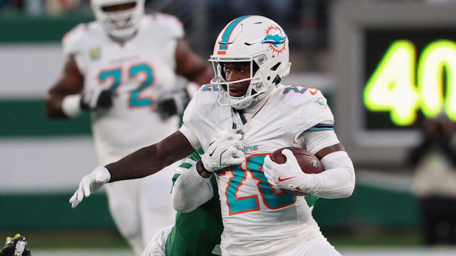 Miami Dolphins running back De'Von Achane (28) runs with the ball while New York Jets cornerback D.J. Reed (4) attempts to tackle him during the first quarter at MetLife Stadium.  | Ed Mulholland-Imagn Images