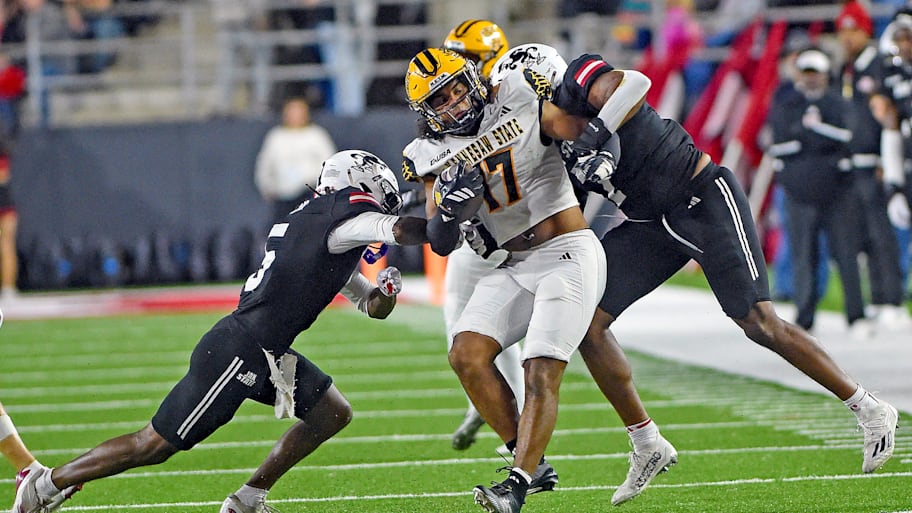 Kennesaw State's Gerard Bullock Jr. tries to evade the tackle of Jacksonville State's Tyrin Taylor and Isaac Walker.