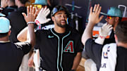 Arizona Diamondbacks Jordan Lawlar receives high-fives in the dugout after hitting a two-run home run off Milwaukee Brewers pitcher Tyler Alexander in the second inning of a spring training game at Salt River Fields at Talking Stick on Feb. 26, 2025.