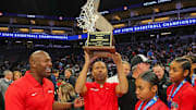 Etiwanda coach Stan Delus holds up the trophy following his team's victory in the California (CIF) State Open Division championship game.