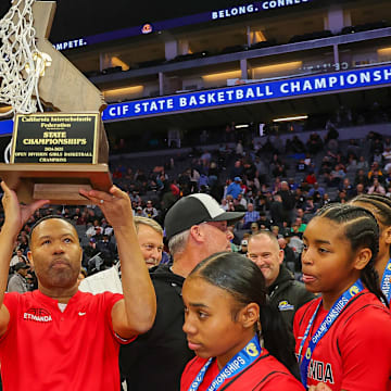Etiwanda coach Stan Delus holds up the trophy following his team's victory in the California (CIF) State Open Division championship game.