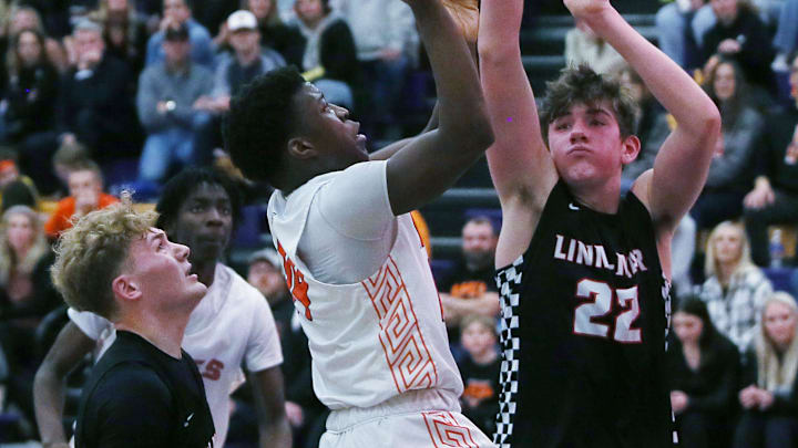 Ames guard Jamison Poe and Linn-Mar's Davis Kern (22) are still battling it out.
