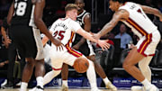 Oct 8, 2025; Miami, Florida, USA;  San Antonio Spurs forward David Jones Garcia (25) threads a pass to center Bismack Biyombo (18) as Miami Heat guard Kasparas Jakucionis (25) and center Kel'El Ware (7) defend during the second half at Kaseya Center. Mandatory Credit: Jim Rassol-Imagn Images