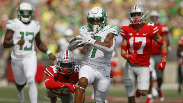 Oregon running back CJ Verdell runs past Ohio State  safety Bryson Shaw (17) and cornerback Cameron Brown (26) for a 77 yards