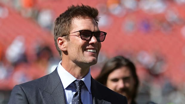 Former NFL quarterback and Las Vegas Raiders minority owner Tom Brady smiles before broadcasting a game.