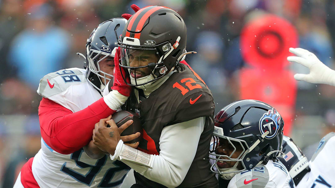 Cleveland Browns quarterback Shedeur Sanders (12) is sacked by Tennessee Titans defensive tackle Jeffery Simmons (98) and linebacker Jaylen Harrell (92) during the first half of an NFL football game at Huntington Bank Field, Dec. 7, 2025, in Cleveland, Ohio.