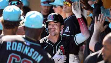 Arizona Diamondbacks Corbin Carroll celebrates in the dugout after hitting a grand slam home run off Milwaukee Brewers pitcher Josh Maciejewski in the second inning of a spring training game at Salt River Fields at Talking Stick on Feb. 26, 2025.
