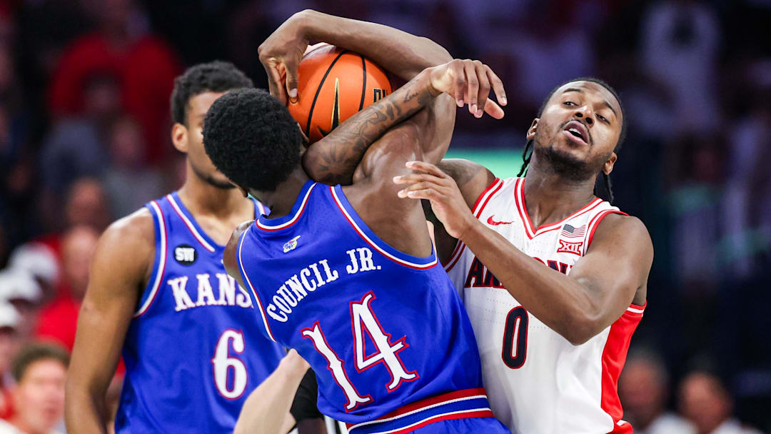 Feb 28, 2026; Tucson, Arizona, USA; Arizona Wildcats guard Jaden Bradley (0) attempts to take the ball from Kansas Jayhawks guard Melvin Council Jr. (14) during the second half of the game at McKale Memorial Center. Mandatory Credit: Aryanna Frank-Imagn Images