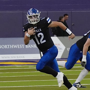 MMCRU's quarterback Eli Harpenau (12) runs with the ball for a first down against MMCRU during the first quarter in the class-A state football championship on Nov. 20, 2025, at UNI Dome in Cedar Falls, Iowa.