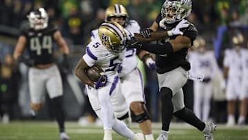Nov 30, 2024; Eugene, Oregon, USA; Washington Huskies wide receiver Giles Jackson (5) catches a pass for a first down during the first half as Oregon Ducks defensive back Kobe Savage (5) is called for face masking on the play at Autzen Stadium. Mandatory Credit: Troy Wayrynen-Imagn Images