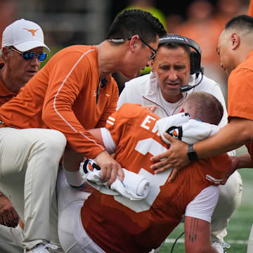 Sep 14, 2024; Austin, Texas, USA; Texas Longhorns head coach Steve Sarkisian (middle) speaks with quarterback Quinn Ewers (3) moments before Ewers left the game early in the second quarter against the UTSA Roadrunners at Darrell K Royal–Texas Memorial Stadium. Mandatory Credit: Sara Diggins/USA TODAY Network via Imagn Images