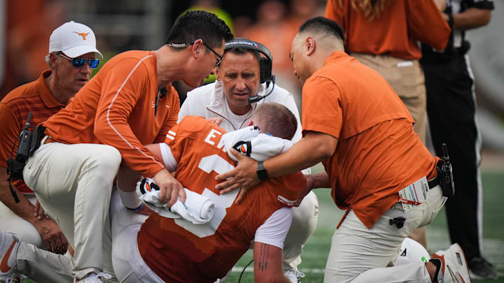 Sep 14, 2024; Austin, Texas, USA; Texas Longhorns head coach Steve Sarkisian (middle) speaks with quarterback Quinn Ewers (3) moments before Ewers left the game early in the second quarter against the UTSA Roadrunners at Darrell K Royal–Texas Memorial Stadium. Mandatory Credit: Sara Diggins/USA TODAY Network via Imagn Images