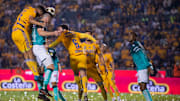 Jugadores de Tigres UANL y de León pelean un balón.