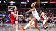 Indiana Fever guard Caitlin Clark passes around Chicago Sky forward Angel Reese.