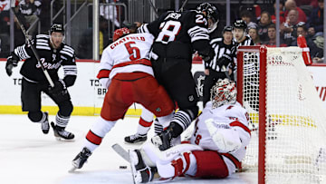 Dec 27, 2024; Newark, New Jersey, USA; Carolina Hurricanes defenseman Jalen Chatfield (5) and New Jersey Devils right wing Timo Meier (28) battle for the puck in front of Carolina Hurricanes goaltender Pyotr Kochetkov (52) during the second period at Prudential Center. Mandatory Credit: Ed Mulholland-Imagn Images