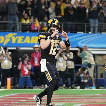 Dec 29, 2023; Arlington, Texas, USA; Missouri Tigers quarterback Brady Cook (12) pretends to take a photo of running back Cody Schrader (7) after he scored a touchdown during the third quarter of the Goodyear Cotton Bowl Classic against the Ohio State Buckeyes at AT&T Stadium. Ohio State lost 14-3.