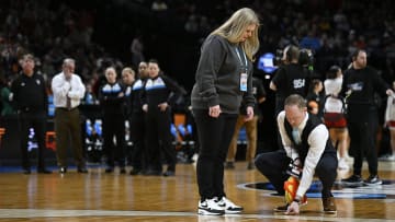 Mar 31, 2024; Portland, OR, USA; NCAA officials measure the three point line while coaches from the