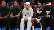 Oct 8, 2025; Miami, Florida, USA;  Miami Heat guard Tyler Herro, center, watches the game against the San Antonio Spurs from the bench at Kaseya Center as he recovers from an injury. Mandatory Credit: Jim Rassol-Imagn Images
