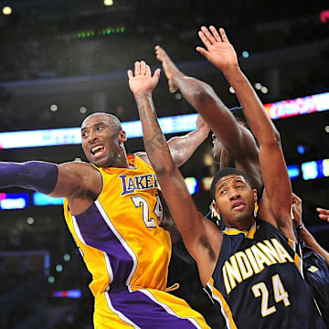 November 27, 2012; Los Angeles, CA, USA; Los Angeles Lakers shooting guard Kobe Bryant (24) turns the ball over against the defense of Indiana Pacers small forward Paul George (24) during the first half at Staples Center. Mandatory Credit: Gary A. Vasquez-Imagn Images