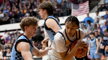 Garfield Heights' Marcus Johnson (right) covers up a rebound as Louisville's Ashton Marshall defends during an OHSAA Division III boys basketball state semifinal at Canton Memorial Field House on Sunday, March 16, 2025.