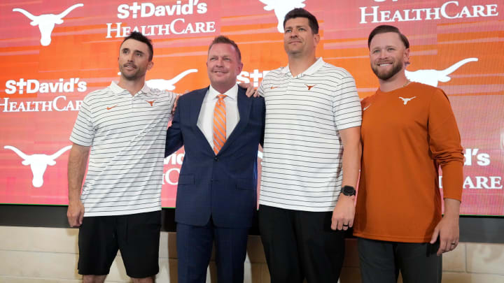 University of Texas baseball coach Jim Schlossnagle, second from left, poses for photos with his assistant coaches, left to right, Michael Earley, Nolan Cain, Max Weinerat his introductory news conference at the Frank Denius Family University Hall of Fame Wednesday June 26, 2024.