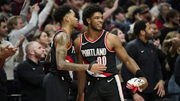 Jan 31, 2024; Portland, Oregon, USA; Portland Trail Blazers guard Scoot Henderson (00) celebrates with guard Anfernee Simons (1) during the second half against the Milwaukee Bucks at Moda Center. Mandatory Credit: Troy Wayrynen-Imagn Images