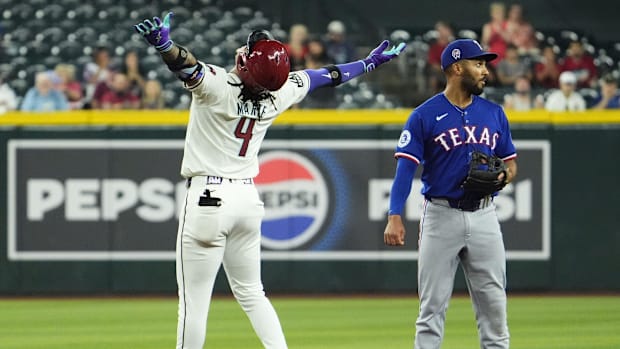 Arizona Diamondbacks Ketel Marte celebrates a double as Texas Rangers second baseman Marcus Semien receives a throw.