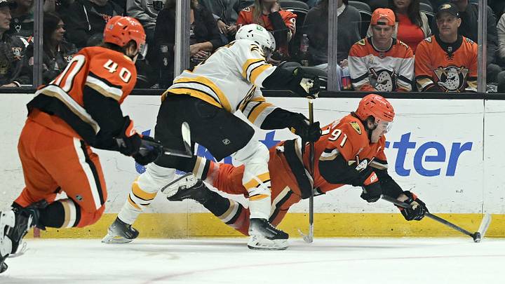 Oct 16, 2026; Anaheim, California, USA;  Anaheim Ducks center Leo Carlsson (91) and Boston Bruins defenseman Hampus Lindholm (27) battle for the puck during the first period at Honda Center.  Mandatory Credit: Griffin Hooper-Imagn Images