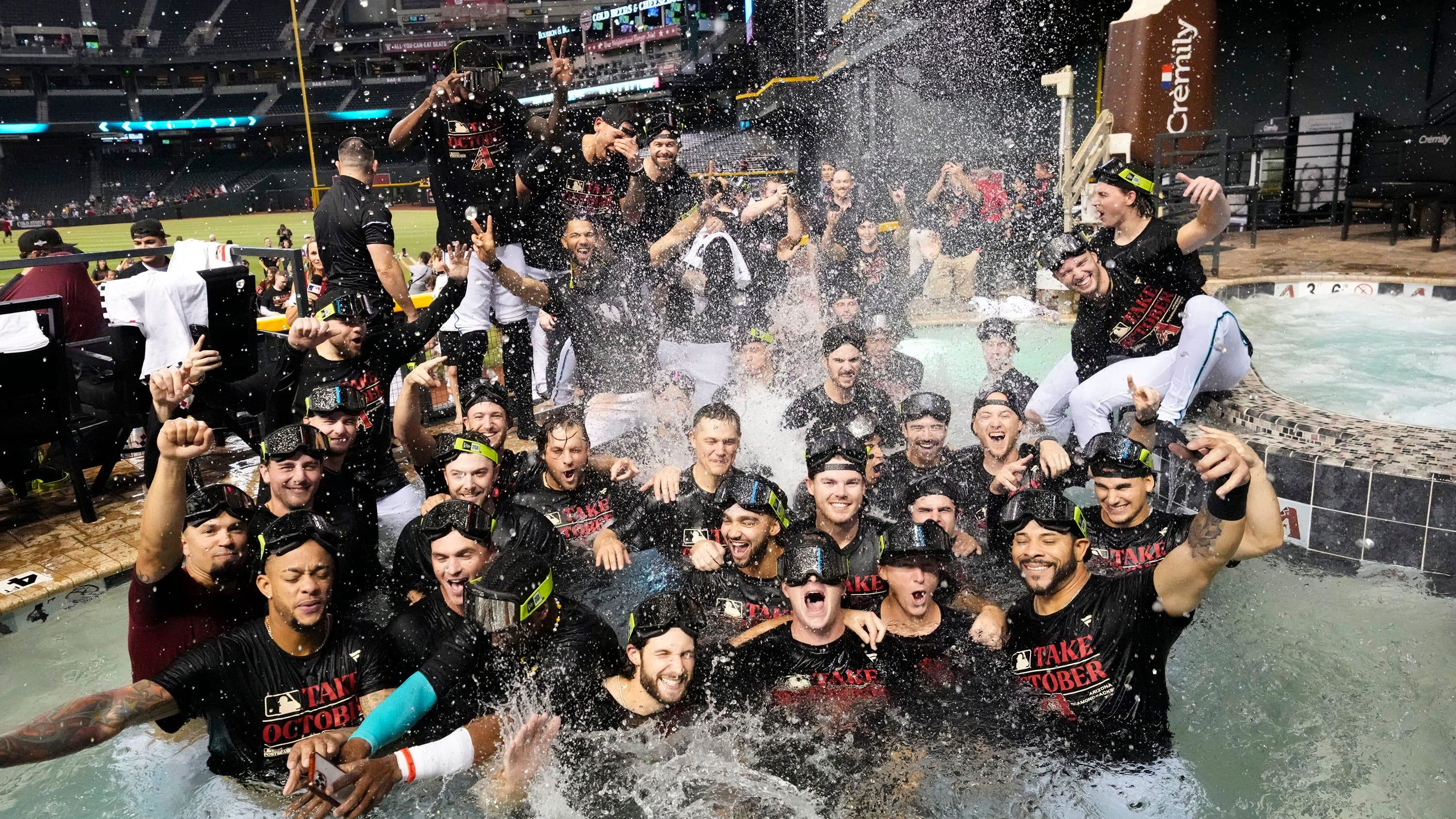 The Arizona Diamondbacks players celebrate in the outfield pool after clinching a wild card playoff