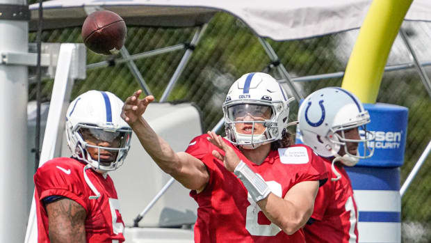 Colts quarterback Jason Bean (red jersey with white helmet) throws a pass during a training camp practice. 