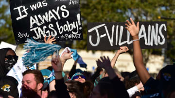 Jaguars fan Eric Hall holds his signs as he joins other fans outside TIAA Bank Field to cheer.