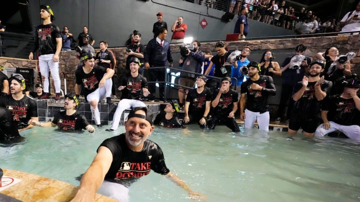 Arizona Diamondbacks manager Torey Lovullo players celebrate in the outfield pool after clinching a wild card playoff spot following their game with the Houston Astros at Chase Field on Sept. 30, 2023.