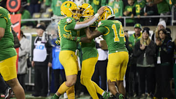 Nov 9, 2024; Eugene, Oregon, USA; Oregon Ducks quarterback Dillon Gabriel (8), left, celebrates after throwing a touchdown pass to wide receiver Evan Stewart (7) during the second half against the Maryland Terrapins at Autzen Stadium. Helping to celebrate is wide receiver Justius Lowe (14). Mandatory Credit: Troy Wayrynen-Imagn Images