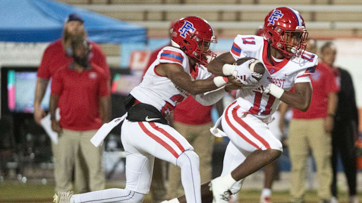 Pine Forest quarterback Zakavius Andrews (No.2)gives the ball to running back Omari Lampkins (No. 11) during Friday night's district matchup against Escambia. Pine Forest quarterback Zakavius Andrews (No.2)gives the ball to running back Omari Lampkins (No. 11) during Friday night's district matchup against Escambia.