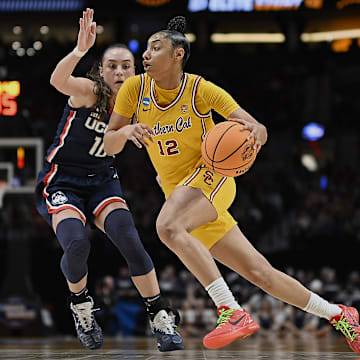 Apr 1, 2024; Portland, OR, USA; USC Trojans guard JuJu Watkins (12) drives to the basket during the second half against UConn Huskies guard Nika Muhl (10) in the finals of the Portland Regional of the NCAA Tournament at the Moda Center. Mandatory Credit: Troy Wayrynen-Imagn Images