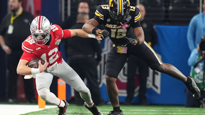 Dec 29, 2023; Arlington, Texas, USA; Ohio State Buckeyes quarterback Lincoln Kienholz (12) is hit out of bounds by Missouri Tigers defensive back Daylan Carnell (13) during the second quarter of the Goodyear Cotton Bowl Classic at AT&T Stadium.