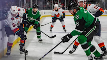 Coachella Valley forward Logan Morrison passes the puck down the boards as Texas defenseman Lian Bichsel closes in on him during the first period of their game at Acrisure Arena in Palm Desert, Calif., Thursday, Dec. 5, 2024.