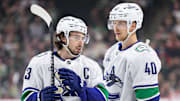 Dec 3, 2024; Saint Paul, Minnesota, USA; Vancouver Canucks defenseman Quinn Hughes (43) and center Elias Pettersson (40) talk before a power play against the Minnesota Wild during the first period at Xcel Energy Center. Mandatory Credit: Matt Krohn-Imagn Images