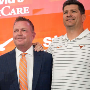 University of Texas baseball coach Jim Schlossnagle, middle, poses for photos with his assistant coaches Michael Earley, left, and Nolan Cain at his introductory news conference at the Frank Denius Family University Hall of Fame Wednesday June 26, 2024.
