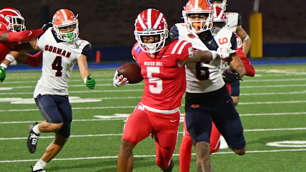 Mater Dei defensive back CJ Lavender Jr. attempts to elude a Bishop Gorman player after making an interception in the Monarch