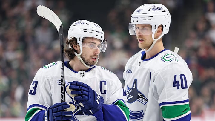 Dec 3, 2024; Saint Paul, Minnesota, USA; Vancouver Canucks defenseman Quinn Hughes (43) and center Elias Pettersson (40) talk before a power play against the Minnesota Wild during the first period at Xcel Energy Center. Mandatory Credit: Matt Krohn-Imagn Images