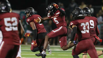 Oaks Christian's Davon Benjamin leaps through an opening after making an interception of a St. Bonaventure pass during the third quarter of the Marmonte League title game on Friday, Oct. 27, 2023, at Oak Christian's Thorson Stadium. Oaks Christian won 13-10.