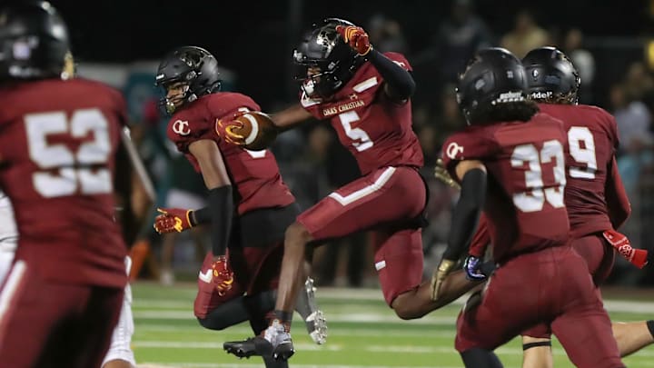 Oaks Christian's Davon Benjamin leaps through an opening after making an interception of a St. Bonaventure pass during the third quarter of the Marmonte League title game on Friday, Oct. 27, 2023, at Oak Christian's Thorson Stadium. Oaks Christian won 13-10.