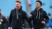 Nov 30, 2025; Charlotte, North Carolina, USA; Carolina Panthers quarterback Andy Dalton (14) and Carolina Panthers quarterback Bryce Young (9) look on before the game against the Los Angeles Rams at Bank of America Stadium. 