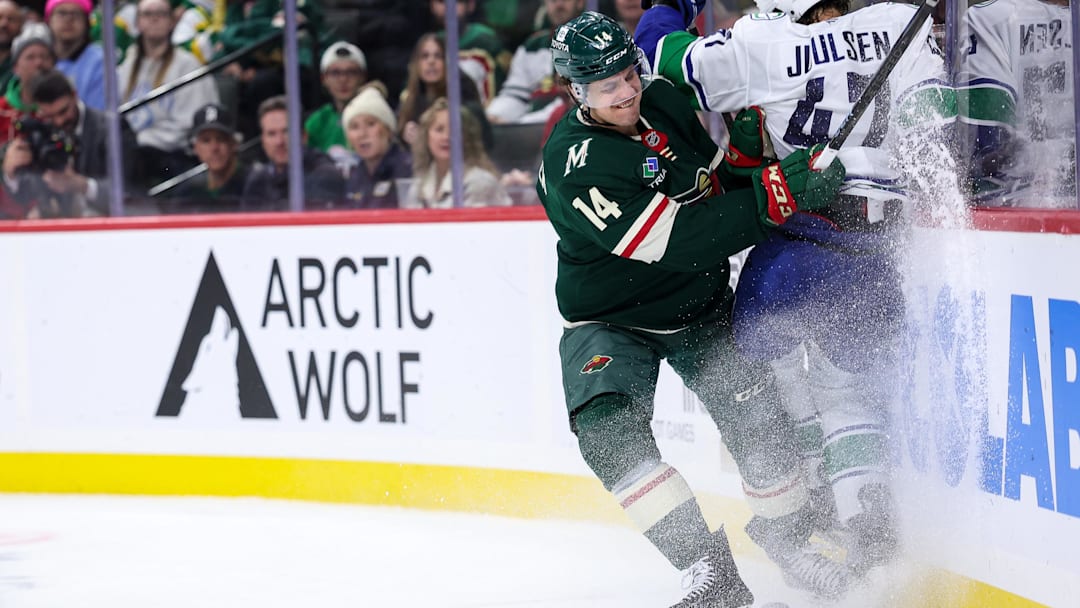 Dec 3, 2024; Saint Paul, Minnesota, USA; Minnesota Wild center Joel Eriksson Ek (14) checks Vancouver Canucks defenseman Noah Juulsen (47) during the third period at Xcel Energy Center. Mandatory Credit: Matt Krohn-Imagn Images