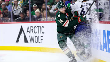 Dec 3, 2024; Saint Paul, Minnesota, USA; Minnesota Wild center Joel Eriksson Ek (14) checks Vancouver Canucks defenseman Noah Juulsen (47) during the third period at Xcel Energy Center. Mandatory Credit: Matt Krohn-Imagn Images