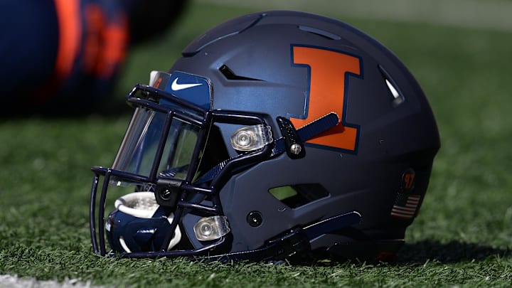 Oct 12, 2019; Champaign, IL, USA; An Illinois Fighting Illini helmet sits on the field as players stretch before the start of the game between the Illinois Fighting Illini and the Michigan Wolverines at Memorial Stadium. Mandatory Credit: Michael Allio-Imagn Images